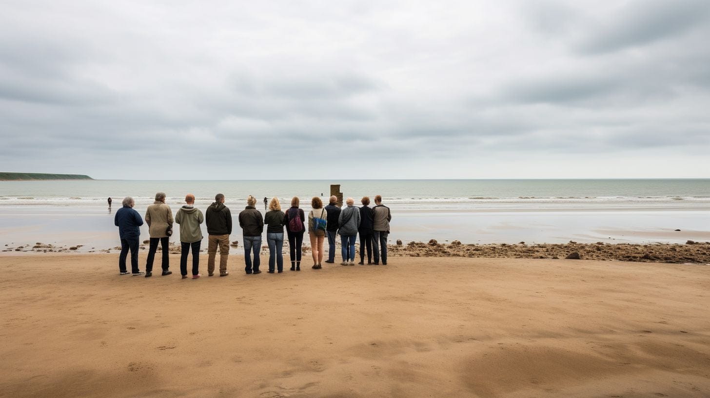 Visitors standing on Omaha Beach, gazing at the horizon.